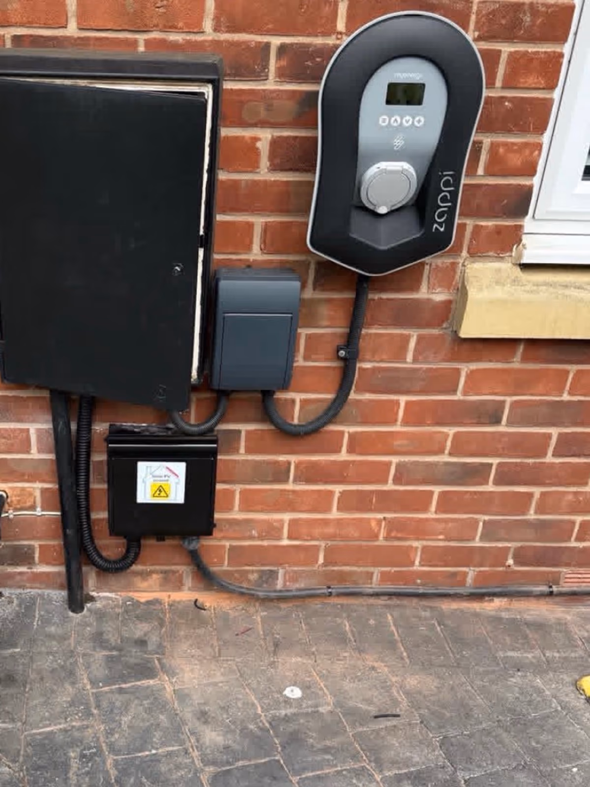 Wall-mounted Zappi EV charger installed on brick