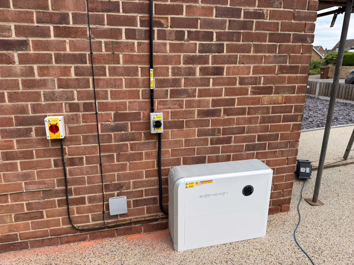 Outdoor battery unit with neat isolators on a brick wall