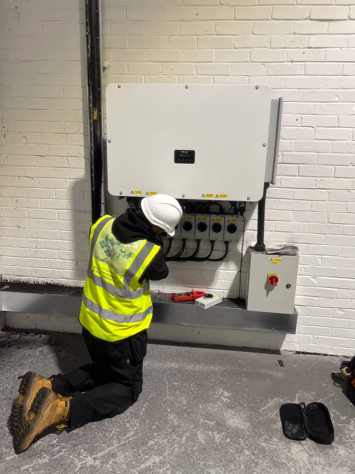 A Renewable Leeds engineer commissioning an inverter on installation day