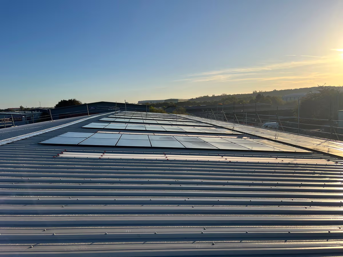 Roof-mounted solar panel array at sunrise, installed by Renewable Leeds